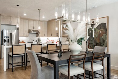 Dining space with light wood finished floors, a textured ceiling, and recessed lighting