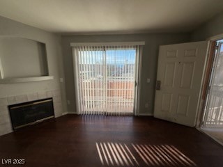 Unfurnished living room featuring a tiled fireplac