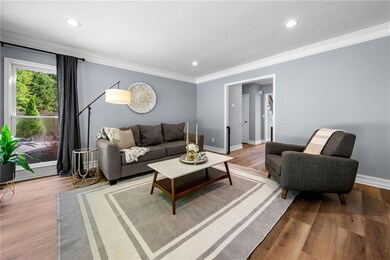 Living room with crown molding, wood finished floo