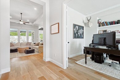 Office featuring built in shelves, ceiling fan, an