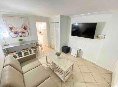 Living area with light tile patterned floors, baseboards, and ornamental molding