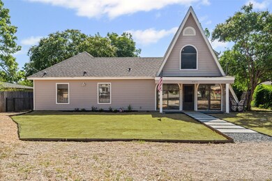 Rear view of house featuring a shingled roof and covered porch