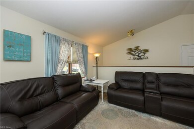 Living room featuring vaulted ceiling and light ca