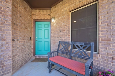 Property entrance with brick siding and a porch