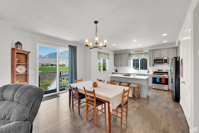 Dining space with a chandelier, recessed lighting, light wood finished floors, and a mountain view