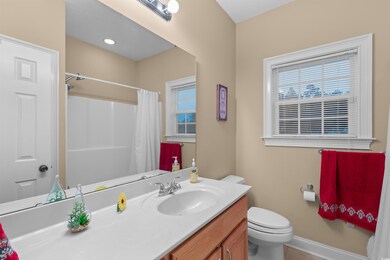 Bathroom with curtained shower, vanity, and toilet