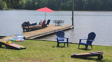 Dock area featuring a water view and a view of tre