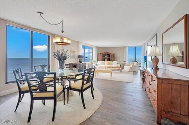Dining area featuring light hardwood / wood-style floors, a water view, floor to ceiling windows, a textured ceiling, and an inviting chandelier