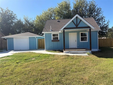 View of front of home with board and batten siding, a porch, an outdoor structure, and roof with shingles