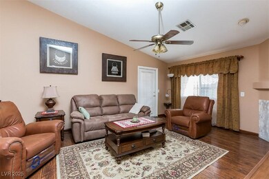 Living room with lofted ceiling, a ceiling fan, an