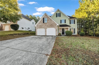 Traditional-style house with concrete driveway, brick siding, a garage, and a front lawn