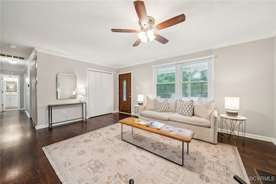 Living area with a ceiling fan, baseboards, crown