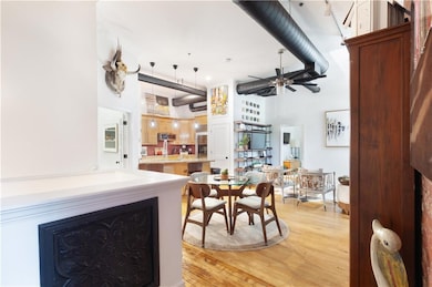 Dining space featuring light wood-style floors, a high ceiling, and a ceiling fan