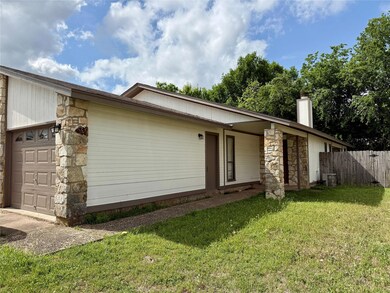 View of home's exterior with a yard, fence, stone