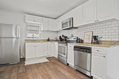 Kitchen featuring white cabinets, hardwood / wood-