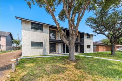 View of front of property with brick siding and a balcony