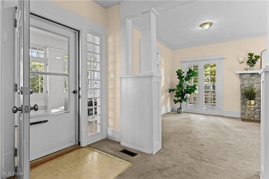 Entryway with carpet flooring and a stone fireplace