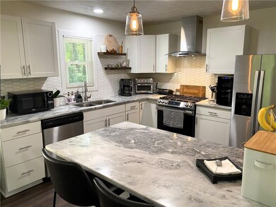 Kitchen featuring wall chimney range hood, applian