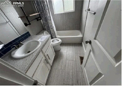 Full bath featuring toilet, vanity, and shower / tub combo