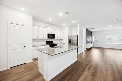Kitchen featuring visible vents, black appliances