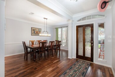 Formal dining room with beautiful lighting and wood floors that flow throughout the home.