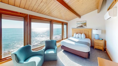 Bedroom featuring a water view, carpet, a wall unit AC, and wooden ceiling