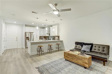 Living room featuring visible vents, recessed lig