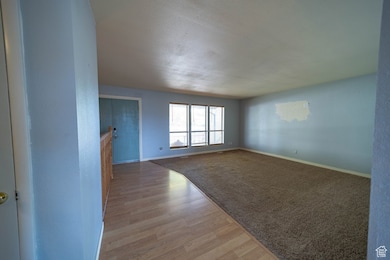 Spare room with light wood-style floors and a textured ceiling