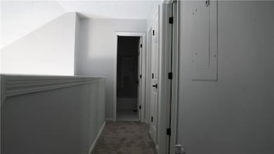 Hall with carpet floors and vaulted ceiling