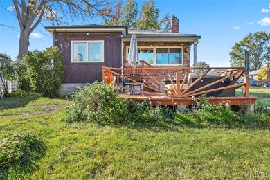 View of front of home featuring a front lawn, a chimney, and a deck