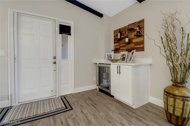 Entryway featuring wine cooler and light hardwood