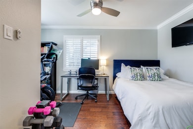 Bedroom with dark wood-style floors, a desk, ceiling fan, and crown molding