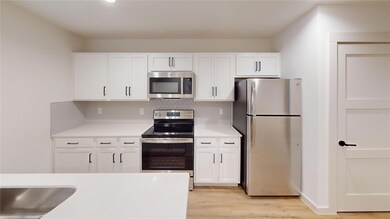 Kitchen with light countertops, tasteful backsplas