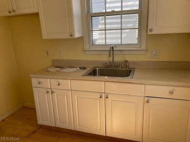 Kitchen featuring light hardwood / wood-style flooring, white cabinetry, and sink