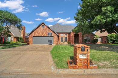 Traditional-style home with a front yard, an attached garage, brick siding, and concrete driveway