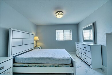 Bedroom featuring light marble finish floors and b