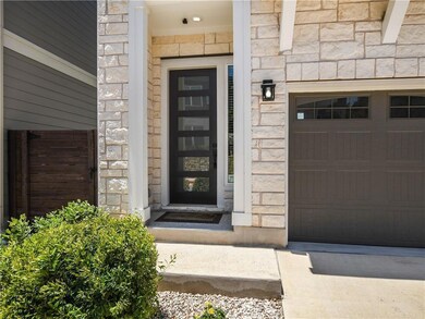Property entrance with stone siding and a garage