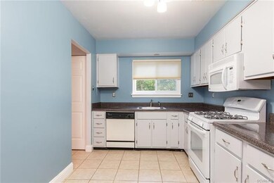 Sunny kitchen with fresh/trendy light grey cabinetry, tile floor, gas cooking and updated counters and hardware.