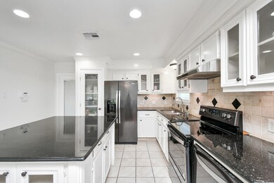 Take a look at this stunning kitchen! Bright recessed lights illuminate the space, highlighting the sleek granite countertops and stainless steel Whirlpool appliances. A large island offers extra storage and additional seating, and under-cabinet lighting enhance functionality. The white pantry with a frosted glass door offers a motion censored slight for hands-free functionality!