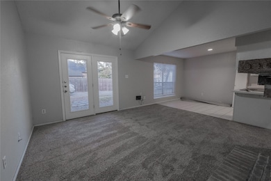 Unfurnished living room featuring light colored carpet, a ceiling fan, and high vaulted ceiling