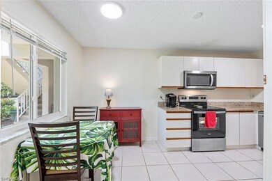 Kitchen featuring stainless steel appliances, a textured ceiling, white cabinets, light countertops, and light tile patterned floors