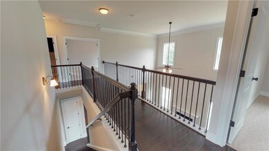 Stock photo of staircase featuring wood finished floors, crown molding, baseboards, and a ceiling fan