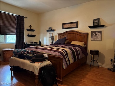 Bedroom with wood finished floors and baseboards