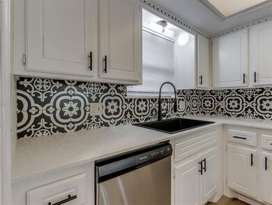 Kitchen featuring stainless steel dishwasher, back