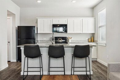 Kitchen with black appliances, white cabinets, a 
