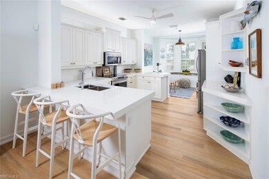 Kitchen featuring appliances with stainless steel finishes, a sink, open shelves, and a peninsula