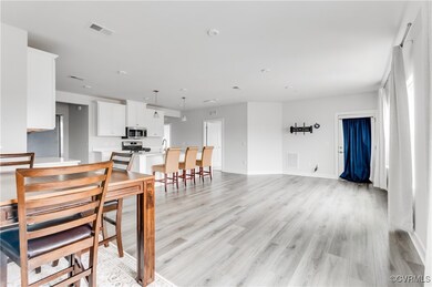 Dining room with light wood-style flooring and bas