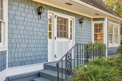 Entrance to property featuring a shingled roof