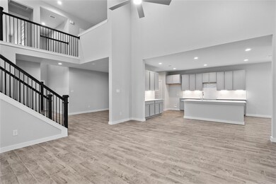 A beautiful view from the family room into kitchen and gorgeous staircase leading to the upstairs.