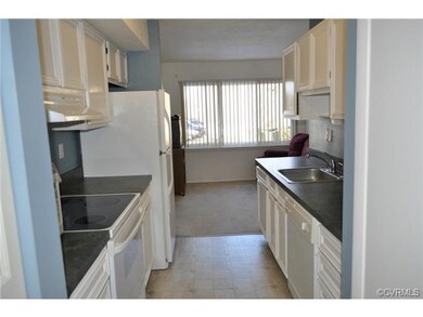 This view of the kitchen shows adjacent living are